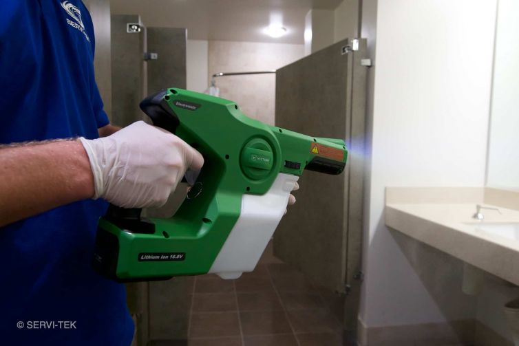 Janitor spraying the comfort rooms