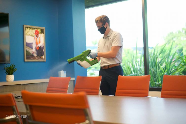 Janitor disinfecting meeting rooms