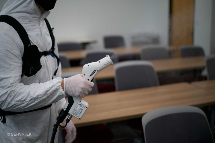 janitor disinfecting office chairs