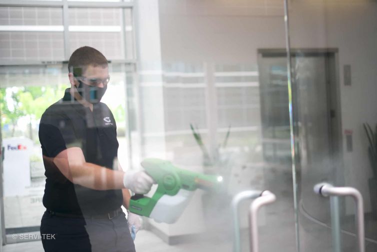 janitor disinfecting door handles